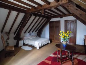 Un dormitorio con una cama y una mesa con flores. en Maison bigourdane en Ayzac-Ost