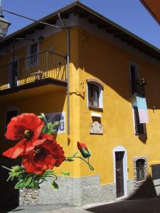 ein gelbes Gebäude mit einem Blumengemälde darauf. in der Unterkunft B&B Il Campo dei Papaveri in Mornese