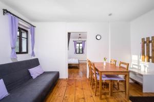 a living room with a table and a couch at Penzion Pod Sudem in Lázně Libverda