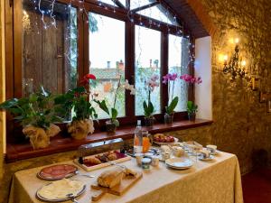 une table avec de la nourriture devant une fenêtre dans l'établissement Villa del lago, à Barberino di Mugello