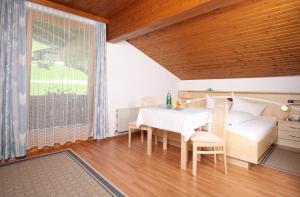 a dining room with a white table and chairs at Hotel Garni Haus Anita in Liesing