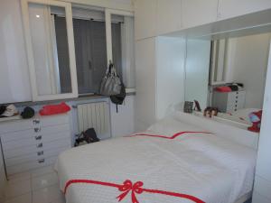 a bedroom with a bed with a red bow on it at Appartamento su Residence in Punta Ala