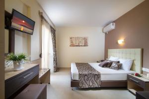 a hotel room with a bed and a flat screen tv at Castro deluxe in Toroni