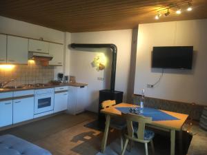 eine kleine Küche mit einem Tisch und einem Herd in der Unterkunft Haus Kammerlander in Stummerberg