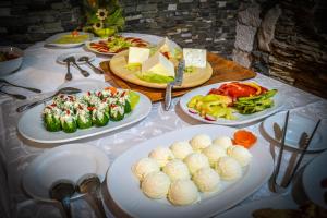 ein Tisch mit Tellern voller Essen in der Unterkunft Hotel Insula in Neptun