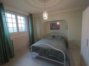 1 dormitorio con cama y lámpara de araña en Les Chambres de KERCHELGEN, en Saint-Sauveur