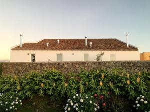 ein Haus hinter einer Steinmauer mit Blumen in der Unterkunft Antiga Fábrica de Chá in Nordestinho + 39 Fotos