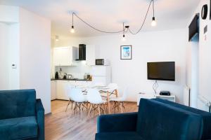 salon z kanapą, stołem i krzesłami w obiekcie Apartment Zamojska 8 - Apartamenty GKM Lublin w mieście Lublin