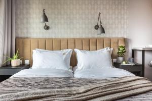 a bedroom with a large bed with white pillows at Fragola Apartments Rajska 3 - modern studios, park in Kraków