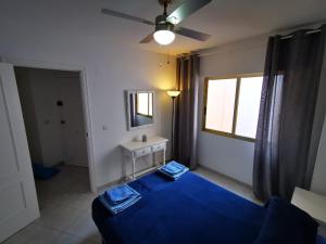 um quarto com uma cama azul e uma janela em Cosy apartment Arenal Bol em Calpe