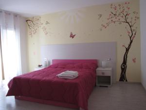 パドゥーラにあるQuattro stagioniのベッドルーム1室(ピンクベッド1台、壁に蝶が飾られた)