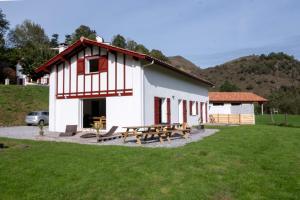 een wit gebouw met een picknicktafel en een bank bij Camp Basque // Maison Erribera // Bidarray in Bidarray