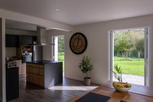 a kitchen with a large window and a clock on the wall at Camp Basque // Maison Erribera // Bidarray in Bidarray