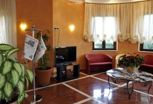 un soggiorno con TV, divano e tavolo di Gullo Hotel a Curinga