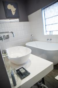a white bathroom with a sink and a tub at Latitude 13 Degrees in Lilongwe