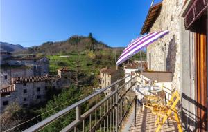 balcón con mesa, sillas y sombrilla en Lovely Apartment In Gioviano -lu- With Kitchen, en Ghivizzano