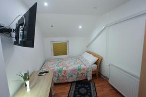 a small room with a bed and a tv at Apartman Carpe Diem 2 in Zaječar
