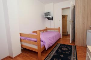 a bedroom with a bed with a purple blanket at Apartman Carpe Diem 2 in Zaječar