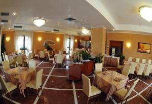 a dining room with tables and chairs in a restaurant at Gullo Hotel in Curinga