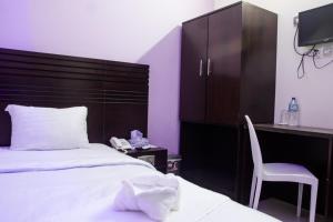 1 dormitorio con cama, escritorio y silla en Royal Palm Hotel, en Sylhet