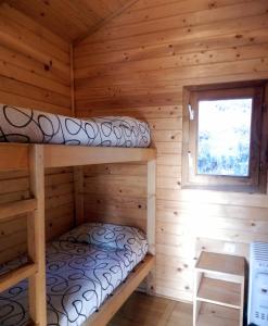 a log cabin with two bunk beds in it at Camping Can Fosses in Planoles