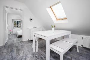 a white dining room with a white table and bench at Jizerské hory, apartmány, zahrada, Penzion Pod Sudem in Lázně Libverda