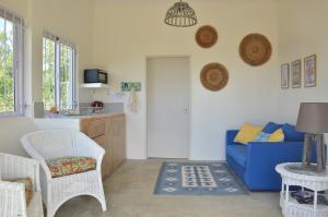a living room with a blue couch and a table at Rodrigues Holiday Family Villa Zourit in Rodrigues Island
