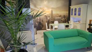a living room with a green couch and a city at BASIC MANSION Šibenik in Šibenik