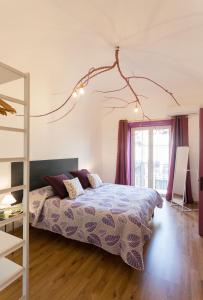 a bedroom with a bed with a purple comforter at Politeama apartment in Palermo