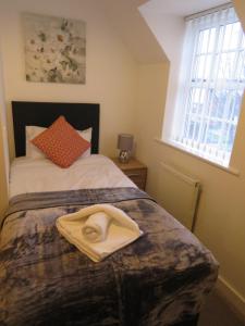 a bedroom with a bed with a hat on it at Hamilton Apartment in Doncaster