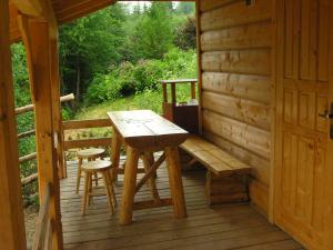 a wooden porch with a bench and a table on a cabin at Mały domek pod lasem in Zakopane
