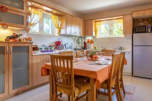een keuken met een tafel en stoelen en een koelkast bij Iris-Gogo House in Nafplio
