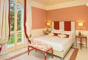 a bedroom with a white bed and windows at Relais Villa Valfiore in San Lazzaro di Savena
