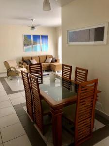uma sala de jantar e sala de estar com mesa e cadeiras em Apartamento Enseada Guarujá - 350m do Mar! no Guarujá