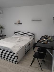 a bedroom with a bed and a table and a desk at Studio Apartment in Chiajna