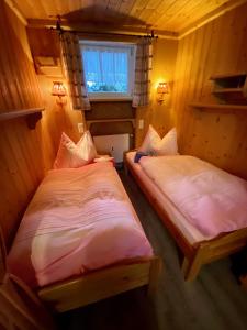 dwa łóżka pojedyncze w pokoju z oknem w obiekcie Posthof 37 w mieście Kitzbühel