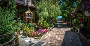 Hotel Insula في نيبتون: حديقة بها زهور على طريق من الطوب بجوار مبنى
