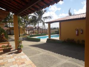 a resort with a swimming pool and palm trees at Pousada O Tabuleiro in Jacumã