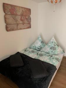 a bed with two pillows and a map on the wall at Apartment Altstadt in Pirna