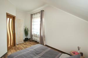 sypialnia z łóżkiem i oknem w obiekcie Apartments by the lake with fireplace w mieście Troki