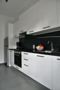 a kitchen with white cabinets and a bowl of fruit at NY Central 3 in Patra