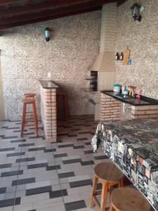 een keuken met een tegelvloer, een aanrecht en krukken bij Casa Jardins in Olímpia