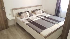 a bed with two pillows on it in a room at Apartman LuMa in Baška Voda