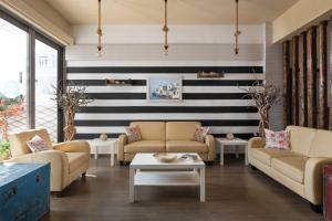 a living room with couches and a striped wall at Panorama Hotel in Gennadi
