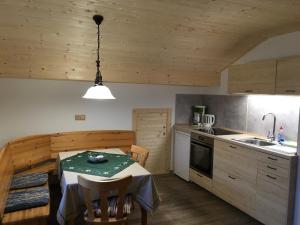 eine Küche mit einem Tisch und eine Küche mit Holzdecken in der Unterkunft Zum Bergbauer in Mittenwald