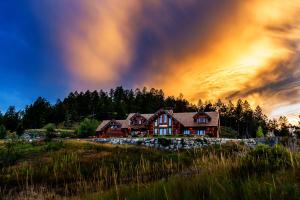 Ein Haus auf einem Hügel mit Regenbogen am Himmel in der Unterkunft Coyote Bluff Estate in Somers