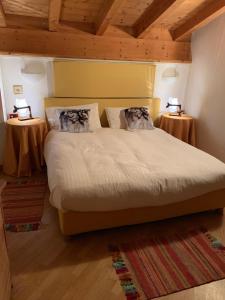 カヴァレーゼにあるChalet montagna e relax Volpe Rossaのベッドルーム1室(大型ベッド1台、テーブル2台付)