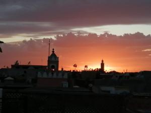 マラケシュにあるDar Margot Marrakechの時計塔のある街の夕日