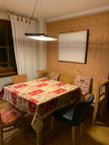 ein Esszimmer mit einem Tisch, Stühlen, einem Tisch und einem Tisch in der Unterkunft Chalet montagna e relax Volpe Rossa in Cavalese