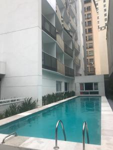 a swimming pool in front of a building at Suites Metrô Luz in Sao Paulo